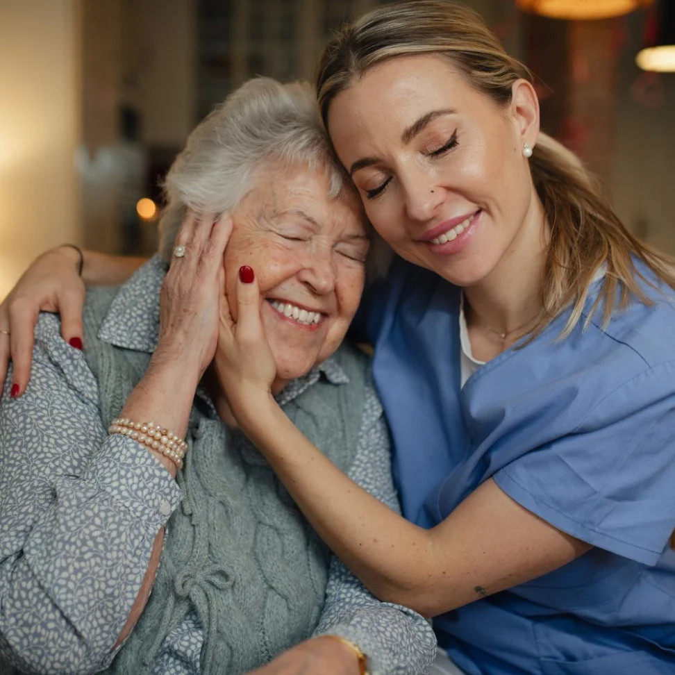 An NDP support worker embracing a smiling participant