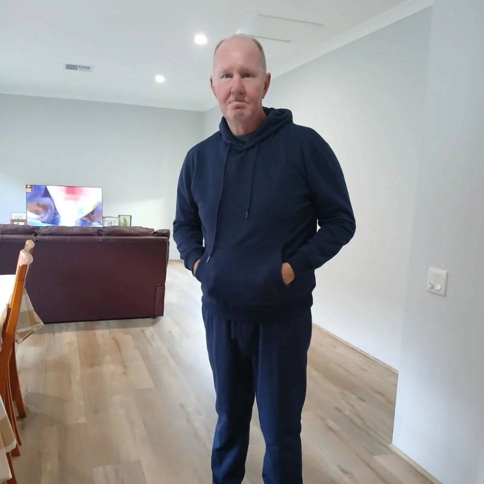 A man standing in the living area of a home